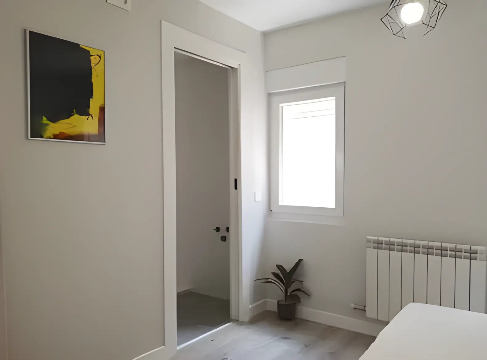 Habitación recién pintada en blanco por Los Pintores Badalona para comunidad de vecinos