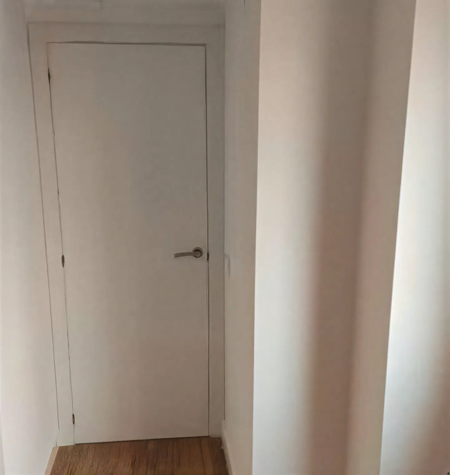 Puerta interior lacada en blanco en pasillo realizada por Los Pintores Badalona